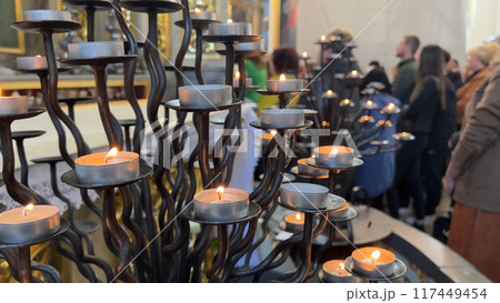 Burning candles in a Catholic church during the Divine Service. 117449454