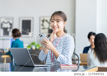 オフィスでスマホを使う若い女性 117449781