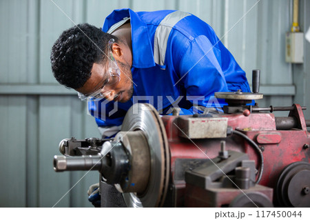 Technician worker man African American wearing uniform safety working machine lathe 117450044