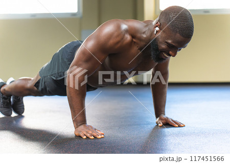 Black man with muscular body doing push-ups 117451566