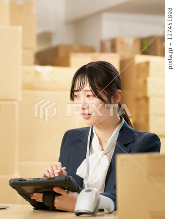 倉庫にてタブレットを使って仕事をする若い女性 物流事務 イメージ 倉庫にてタブレットを使って仕事をする若い女性 物流事務 イメージ 117451898