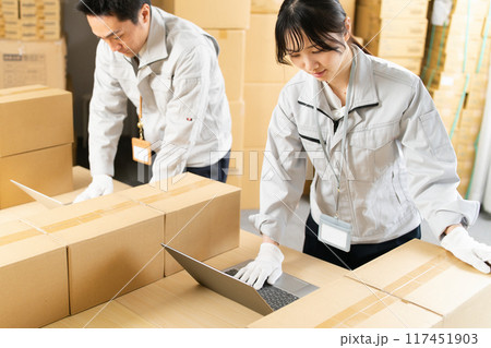 PCのセットアップ作業をする作業服の男女 117451903