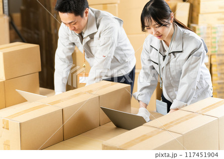 PCのセットアップ作業をする作業服の男女 117451904