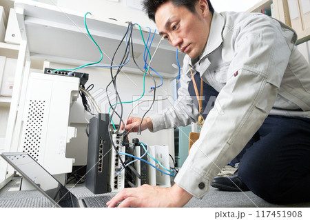 ネットワークの保守点検をする作業服の男性 117451908