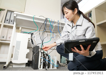 社内ネットワークを管理する作業服の女性 117451911
