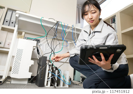 社内ネットワークを管理する作業服の女性 117451912