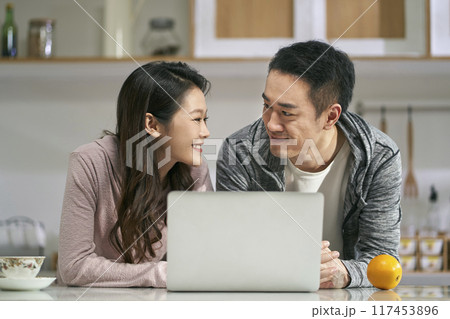 young asian couple using laptop computer together at home young asian couple using laptop computer together at home 117453896
