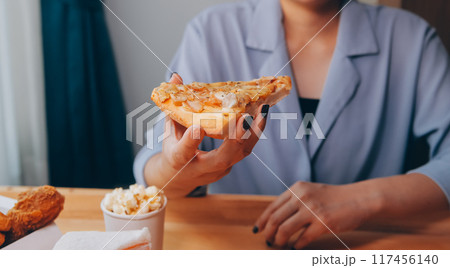 Cropped image of woman holding pizza slice at restaurant 117456140