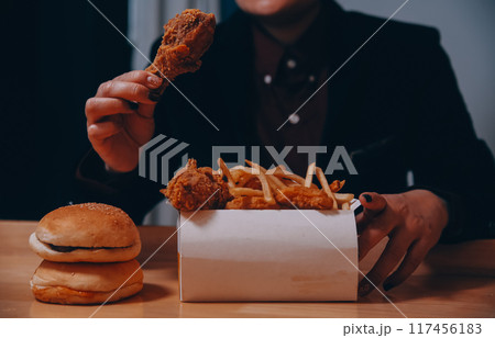 close up focus woman hand hold fried chicken for eat,girl with fast food concept close up focus woman hand hold fried chicken for eat,girl with fast food concept 117456183
