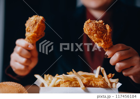 close up focus woman hand hold fried chicken for eat,girl with fast food concept close up focus woman hand hold fried chicken for eat,girl with fast food concept 117456184