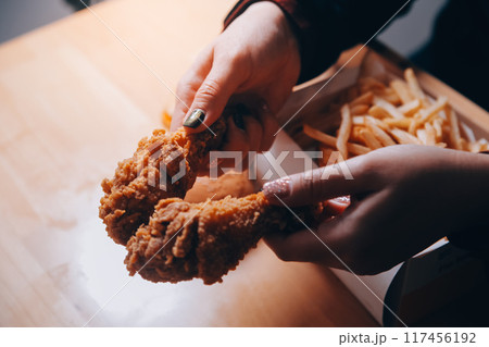 close up focus woman hand hold fried chicken for eat,girl with fast food concept close up focus woman hand hold fried chicken for eat,girl with fast food concept 117456192