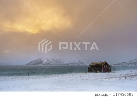 Winter Norway landscape with rorbu on the ocean beach and snow Winter Norway landscape with rorbu on the ocean beach and snow 117456595