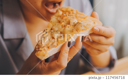 Cropped image of woman holding pizza slice at restaurant 117456718