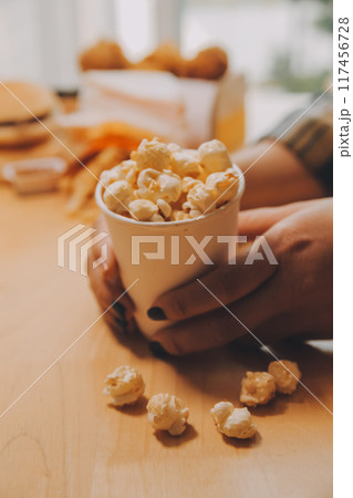 A woman holding a bowl of popcorn 117456728