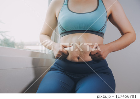 fat woman, fat belly, chubby, obese woman hand holding excessive belly fat with measure tape, woman diet lifestyle concept fat woman, fat belly, chubby, obese woman hand holding excessive belly fat with measure tape, woman diet lifestyle concept 117456781