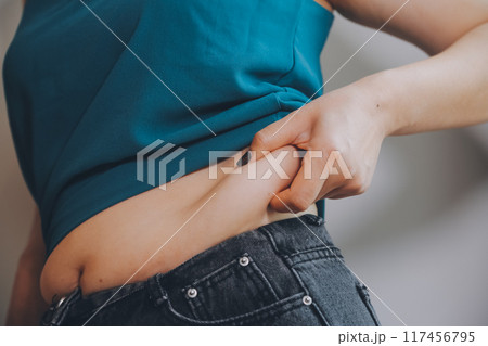 fat woman, fat belly, chubby, obese woman hand holding excessive belly fat with measure tape, woman diet lifestyle concept fat woman, fat belly, chubby, obese woman hand holding excessive belly fat with measure tape, woman diet lifestyle concept 117456795