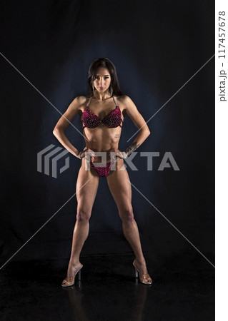 Beautiful athletic girl on a dark background Beautiful athletic girl on a dark background 117457678