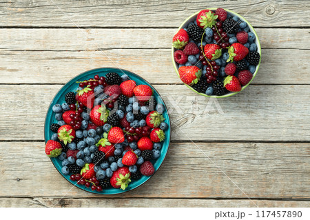Mix of ripe colorful berries in bowl photography . Blueberry , strawberry , raspberry , blackberry and red currant . Top view Mix of ripe colorful berries in bowl photography . Blueberry , strawberry , raspberry , blackberry and red currant . Top view 117457890