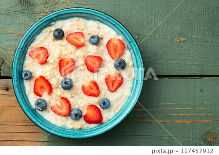 Homemade breakfast . Oatmeal with milk and berries . Top view 117457912