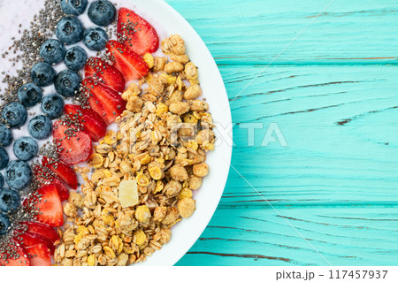Healthy breakfast . Yogurt with berries ( strawberry , raspberry , blueberry , blackberry ) , granola and chia seeds . Top view 117457937