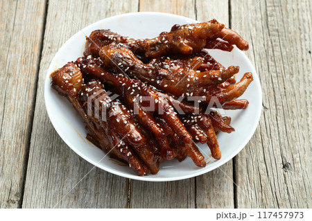 Caramelized korean or Chinese chicken foots ( paws ) with sesame . Top view 117457973