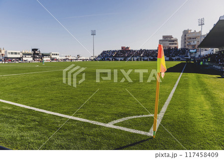 Closeup red flag in a football ground corner with bright blue sky 117458409