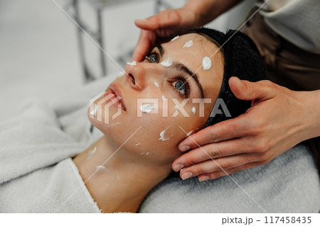 Relaxing skincare treatment with cream application in a spa setting during daytime Relaxing skincare treatment with cream application in a spa setting during daytime 117458435