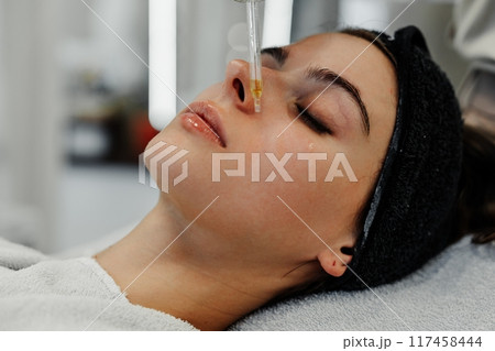 Young woman enjoying facial treatment at spa in relaxing atmosphere during daytime appointment Young woman enjoying facial treatment at spa in relaxing atmosphere during daytime appointment 117458444