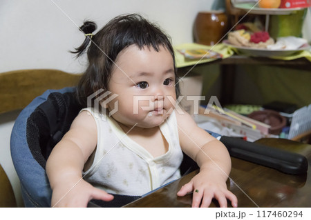 【離乳食を食べる髪を結んだ赤ちゃん】 117460294