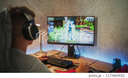 Caucasian teenager plays 3D third person shooter on computer 117460492