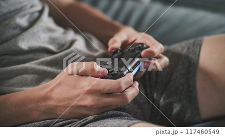 Close up hands of Caucasian young boy using wireless controller 117460549