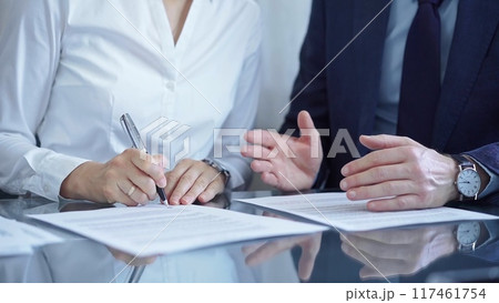 Business people wearing suits signing important documents during a corporate meeting. Win-win concept 117461754
