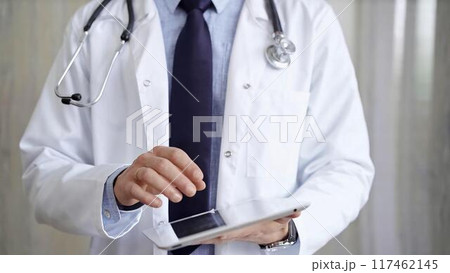 Doctor man wearing lab coat and stethoscope using tablet computer in hospital. Medicine and science 117462145