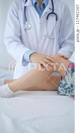 Doctor and kid patient. Orthopedist examining girl's knee in medical clinic. Medicine and health care Doctor and kid patient. Orthopedist examining girl's knee in medical clinic. Medicine and health care 117462167