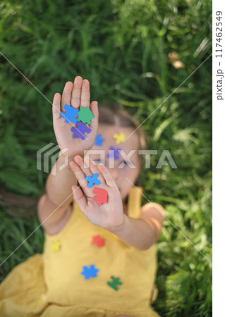 Close-up of the girl's palms, strewn with colored paper puzzles Close-up of the girl's palms, strewn with colored paper puzzles 117462549