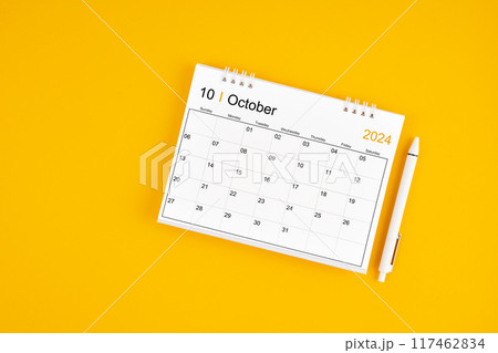 October 2024, Monthly desk calendar for 2024 year and pen on yellow background. October 2024, Monthly desk calendar for 2024 year and pen on yellow background. 117462834
