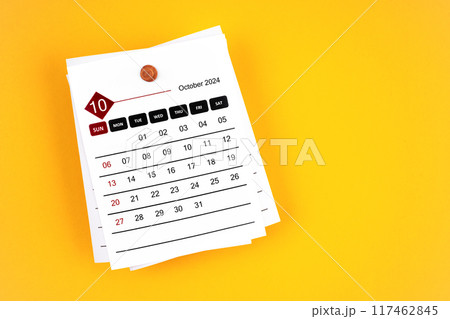 October 2024 calendar page with wooden push pin on yellow background. October 2024 calendar page with wooden push pin on yellow background. 117462845