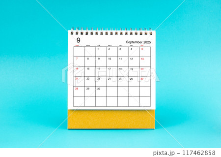 September 2025 desk calendar on blue background. 117462858