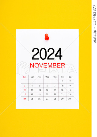 November 2024 calendar page with push pin on yellow background. November 2024 calendar page with push pin on yellow background. 117462877