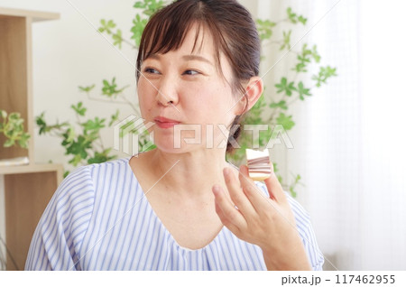 お菓子を食べてリラックスするミドル女性 お菓子を食べてリラックスするミドル女性 117462955