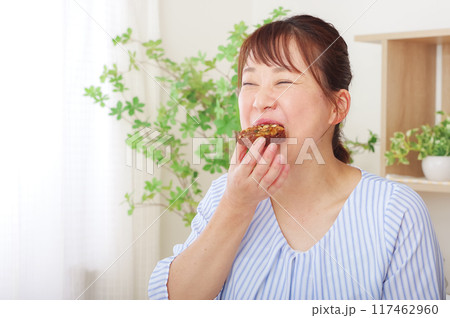 お菓子を食べてリラックスするミドル女性 お菓子を食べてリラックスするミドル女性 117462960