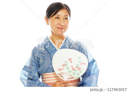 高級浴衣の絹紅梅を着て団扇を持つ笑顔の中年女性 高級浴衣の絹紅梅を着て団扇を持つ笑顔の中年女性 117463057