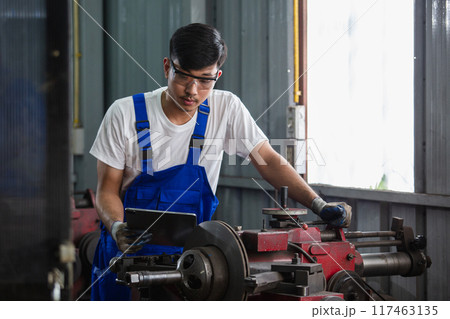 Asian man engineer using digital tablet workers check up usage of brake disc grinder Asian man engineer using digital tablet workers check up usage of brake disc grinder 117463135