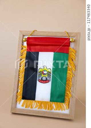 Small flag of UAE in beige background. Copy space. Mock up advertisement template. Tourism travel voucher with United Arab Emirates national symbol. Visit Dubai 117463340