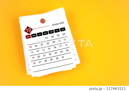 October 2025 calendar page with wooden push pin on yellow background. October 2025 calendar page with wooden push pin on yellow background. 117463521