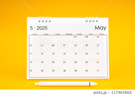May 2025, Monthly desk calendar for 2025 year and pen on yellow background. 117463668