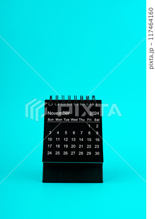 Black Calendar for November 2024. Desktop calendar on a green background. 117464160