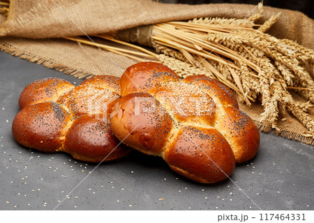 Freshly baked braided challah bread topped with sesame and poppy seeds, perfect for any meal Freshly baked braided challah bread topped with sesame and poppy seeds, perfect for any meal 117464331