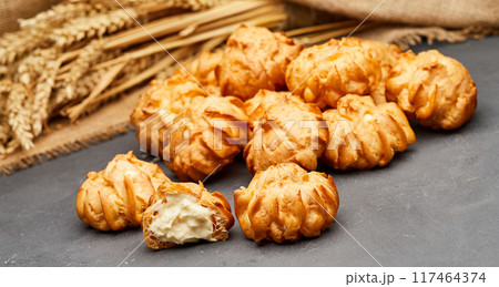 Delicious cream-filled profiteroles, golden and crisp, perfect for a sweet dessert treat Delicious cream-filled profiteroles, golden and crisp, perfect for a sweet dessert treat 117464374