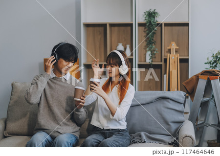 Asian Female discussing new project with male colleague. Young woman talking with young Asian man with financial on sofa in home office Asian Female discussing new project with male colleague. Young woman talking with young Asian man with financial on sofa in home office 117464646
